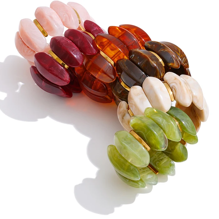 "Adalaide Bangle — chunky marbled resin beads in a sculptural wave design, finished with polished gold spacer links. A bold pop of color for stacking or wearing solo. Available in six rich marbled tones."