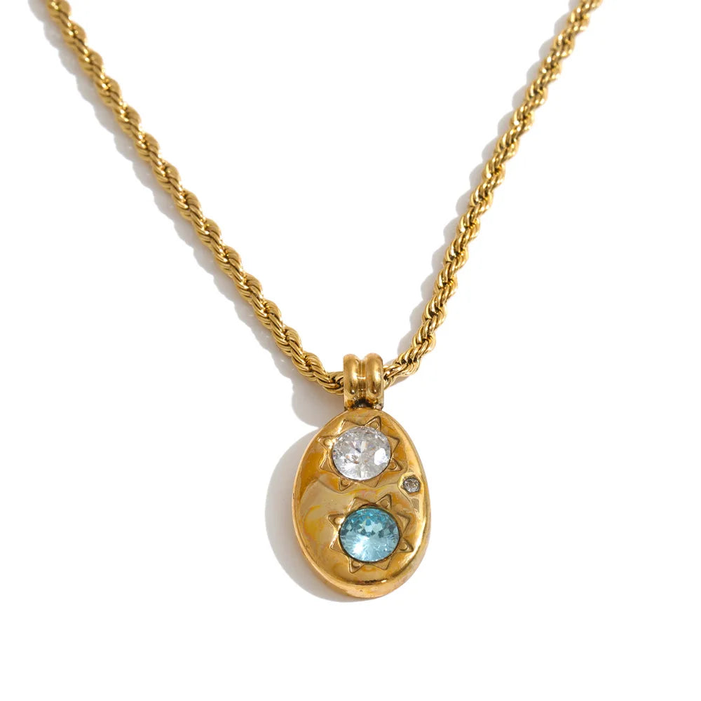 Shop the Alba Necklace: celestial-inspired oval pendant with aqua blue zircon. Waterproof stainless steel, silver or 18k gold-tone.