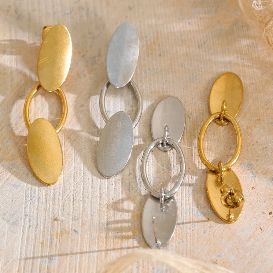 Shop the Emily Earrings: minimalist brushed-finish oval drops in silver or 18k gold-tone. Waterproof, hypoallergenic stainless steel.
