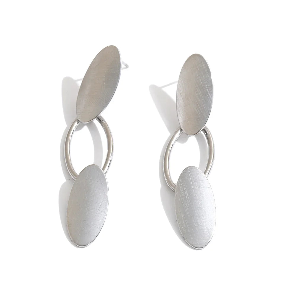 Shop the Emily Earrings: minimalist brushed-finish oval drops in silver or 18k gold-tone. Waterproof, hypoallergenic stainless steel.