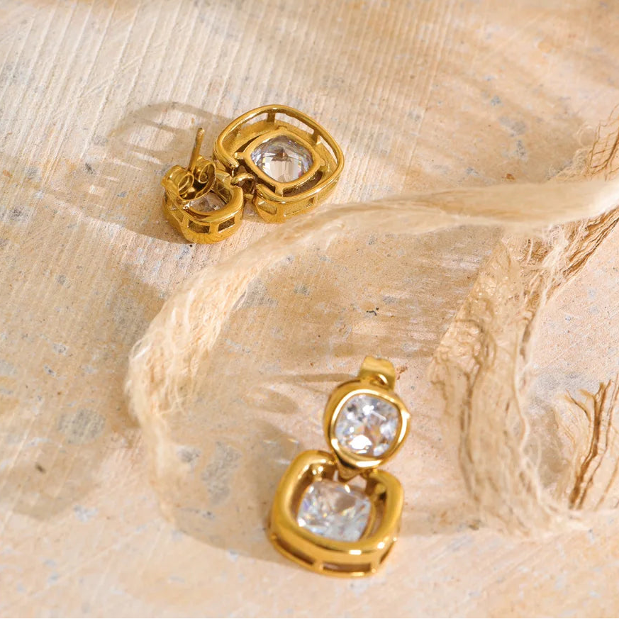 Shop the Sophie Earrings: modern drop studs with stacked cushion-cut zircons. Waterproof, hypoallergenic stainless steel in 18k gold-tone.
