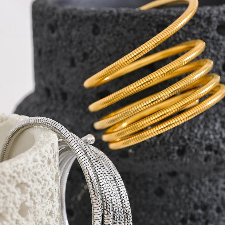 Gold and silver bangles on a textured black and white surface