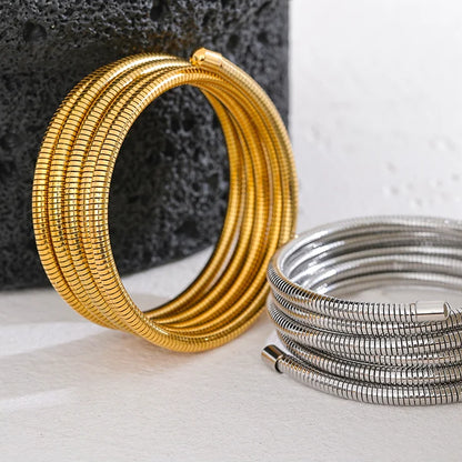 Gold and silver bangles on a textured surface