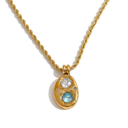 Shop the Alba Necklace: celestial-inspired oval pendant with aqua blue zircon. Waterproof stainless steel, silver or 18k gold-tone.