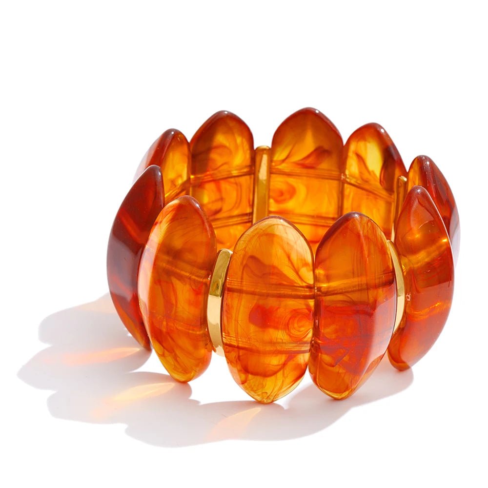 "Adalaide Bangle — chunky marbled resin beads in a sculptural wave design, finished with polished gold spacer links. A bold pop of color for stacking or wearing solo. Available in six rich marbled tones."