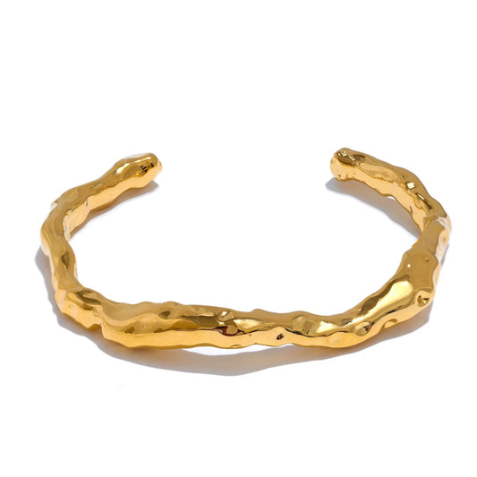 Gold bracelet with a textured design on a white background.Stainless steel bangle.