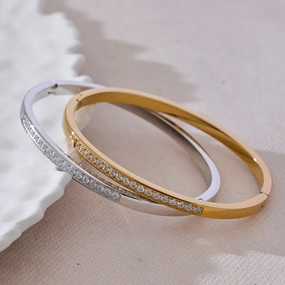 Two gold and silver bangles on a textured surface