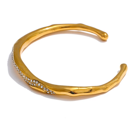 Gold bracelet with small stones on a white background