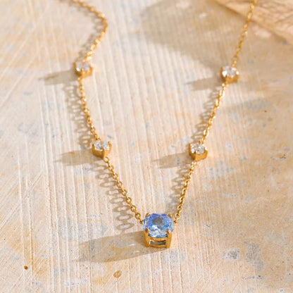 Shop the Bella Necklace: dainty gold station necklace with a blue zircon pendant. Waterproof, hypoallergenic stainless steel, adjustable.