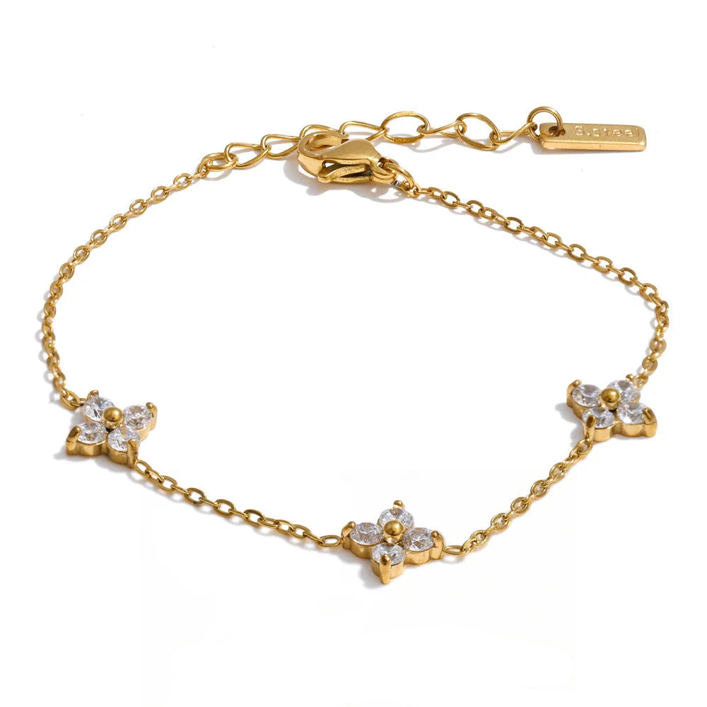 Gold bracelet with floral designs on a white background