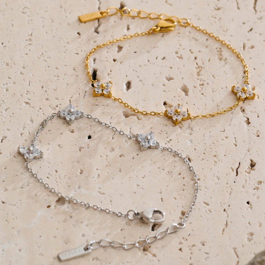 Two gold and silver bracelet sets on a textured beige surface