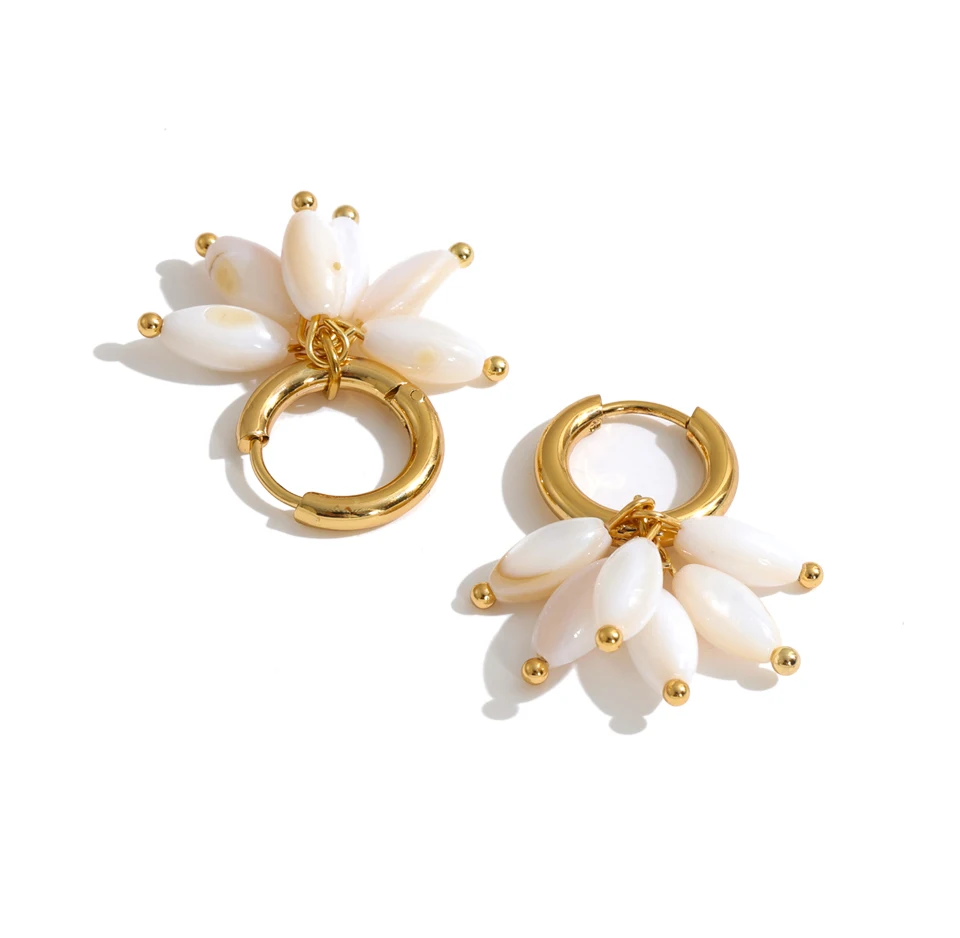 A pair of gold hoop earrings with dangling flower charms made of glossy white shell-like petals and small gold bead accents, shown on a clean white background.
