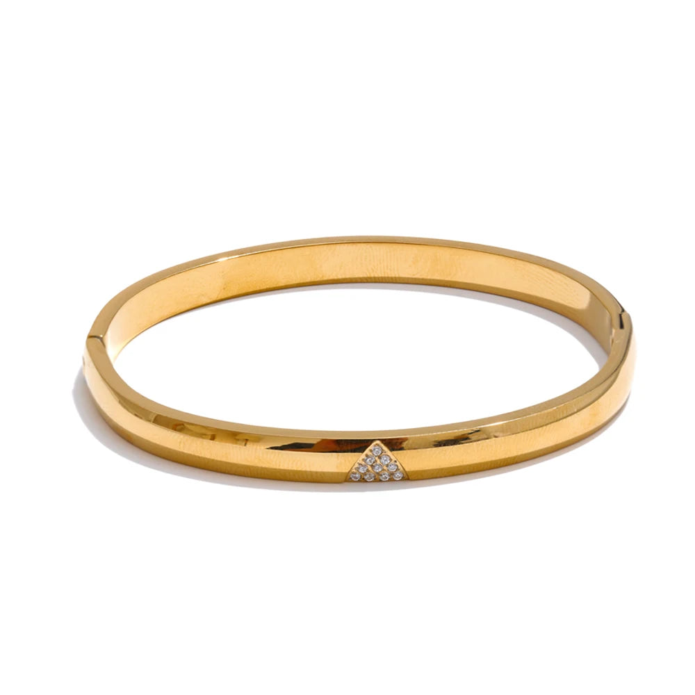 Gold bangle with a small diamond on a white background