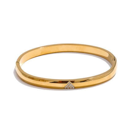 Gold bangle with a small diamond on a white background