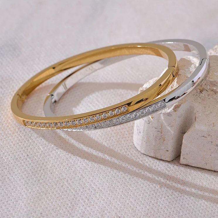 Gold and silver bangles on a textured white surface