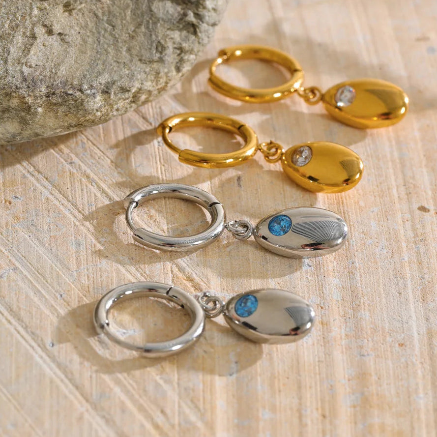Shop the Helena Earrings: hinged huggies with a smooth oval drop and zircon accent. Waterproof stainless steel, silver or 18k gold.