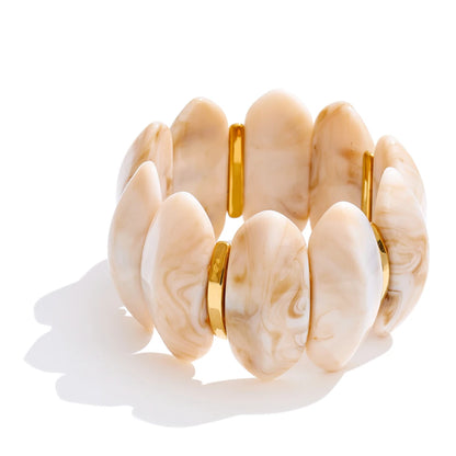 Shell bracelet with gold accents on a white background