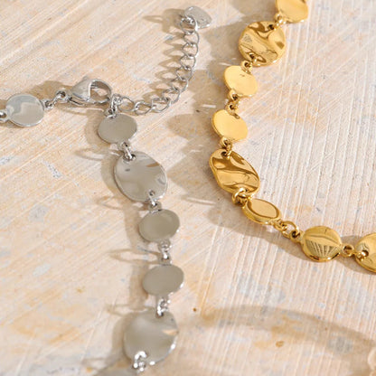 Shop the Jessica Necklace: bold organic disc necklace with a wavy, light-catching finish. Waterproof stainless steel, adjustable fit.