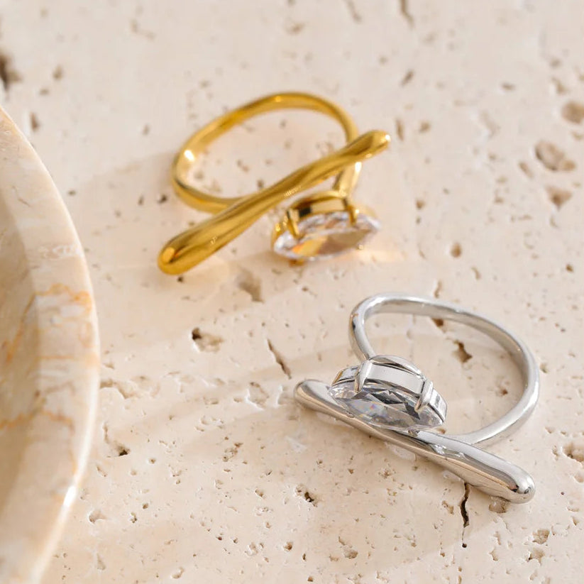 Gold and silver rings on a textured beige surface