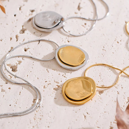 Close-up of gold and silver necklaces on a textured surface