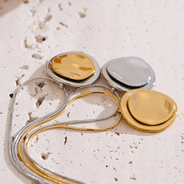 Jewelry set with gold and silver components on a textured surface