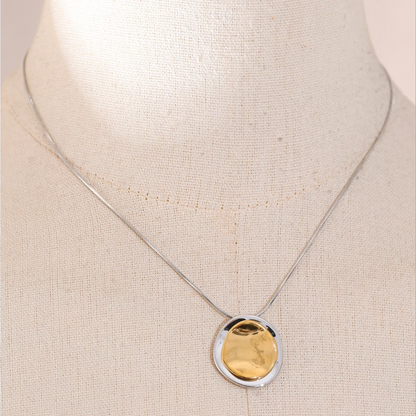 Necklace with a gold pendant on a beige background