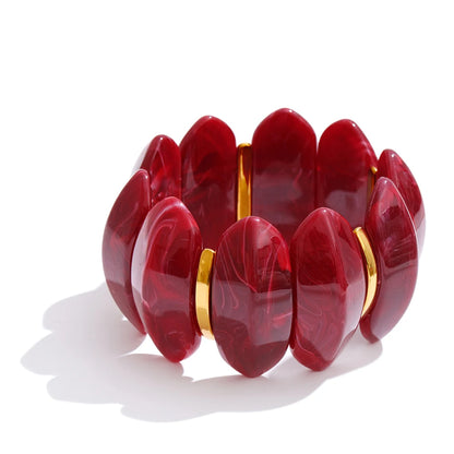 red beaded bracelet with gold accents on a white background