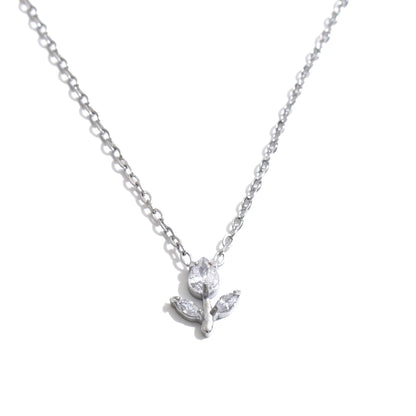 A delicate silver chain necklace featuring a small pendant with a clear faceted flower and two leaves, displayed against a solid white background.