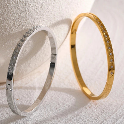 Silver and gold bracelets on a textured white surface