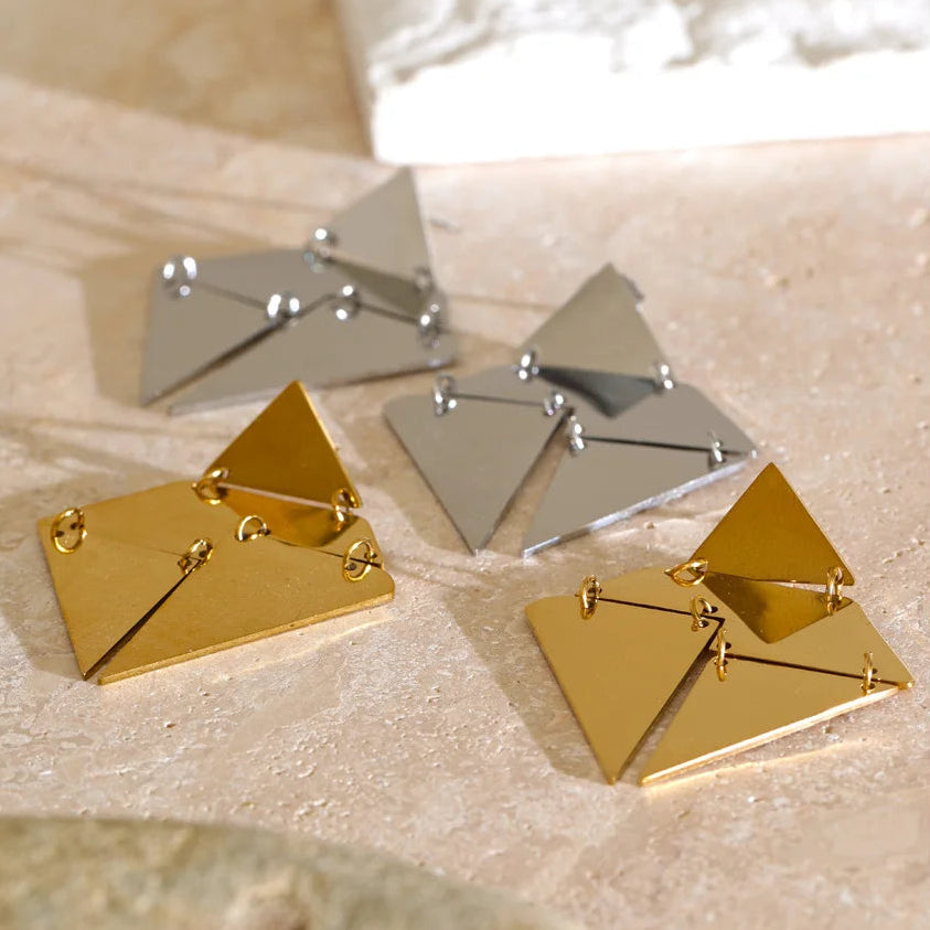 Two pairs of geometric pyramid-shaped earrings in polished gold and silver finishes, stainless steel