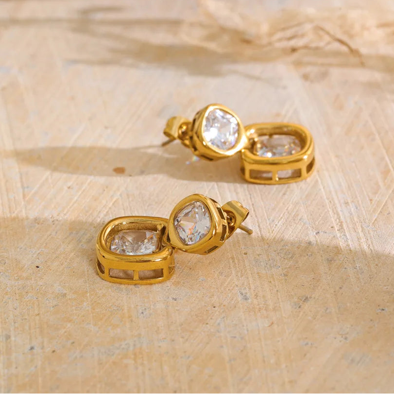 Shop the Sophie Earrings: modern drop studs with stacked cushion-cut zircons. Waterproof, hypoallergenic stainless steel in 18k gold-tone.