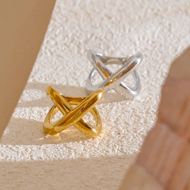 Gold and silver ring on a textured beige surface