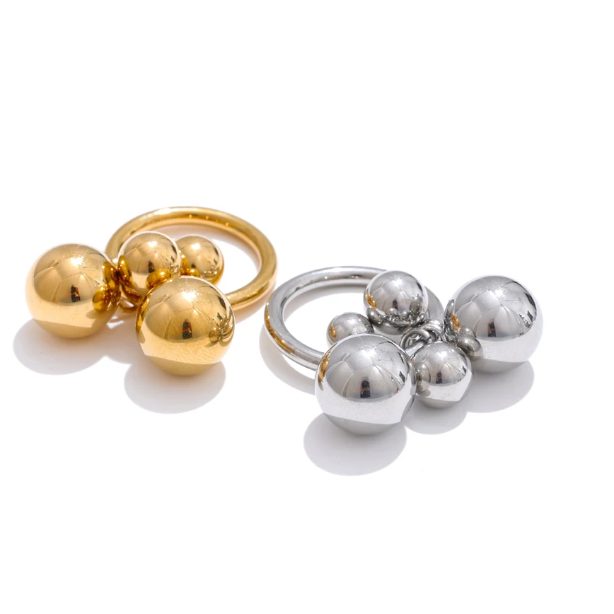 Gold and silver ring with spherical designs on a white background
