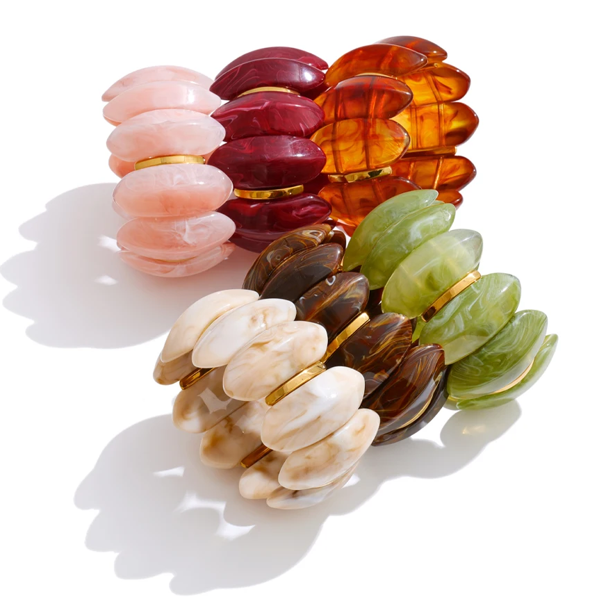 "Adalaide Bangle — chunky marbled resin beads in a sculptural wave design, finished with polished gold spacer links. A bold pop of color for stacking or wearing solo. Available in six rich marbled tones."