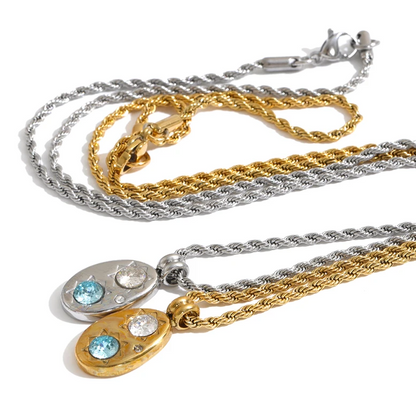 Shop the Alba Necklace: celestial-inspired oval pendant with aqua blue zircon. Waterproof stainless steel, silver or 18k gold-tone.