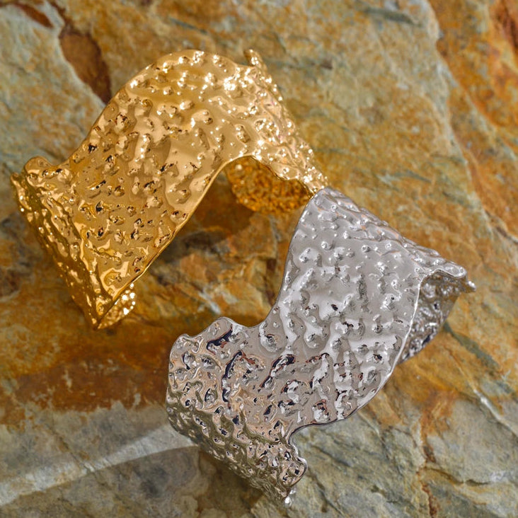 Gold and silver textured bangle on a stone surface