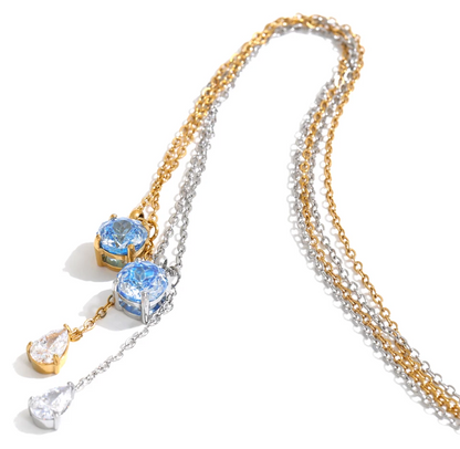 Shop the Astrid Necklace: delicate lariat with blue and clear zircons. Waterproof, hypoallergenic stainless steel in silver or 18k gold.