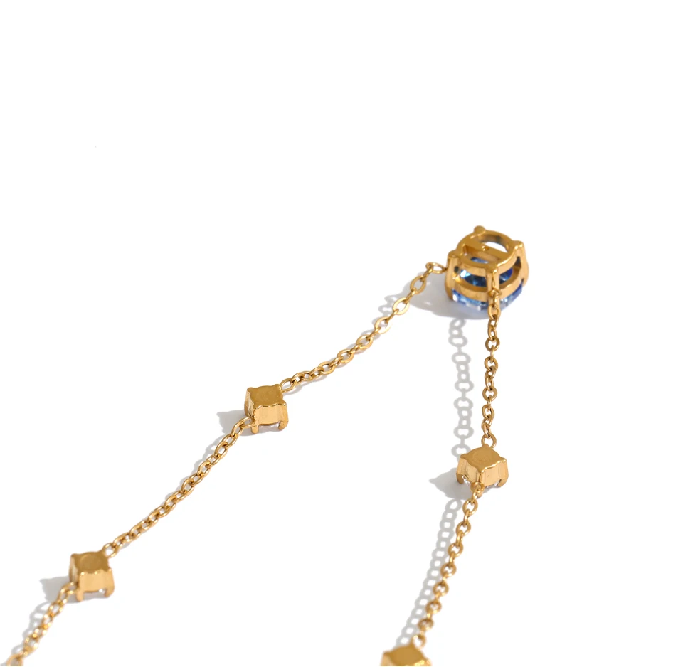 Shop the Bella Necklace: dainty gold station necklace with a blue zircon pendant. Waterproof, hypoallergenic stainless steel, adjustable.