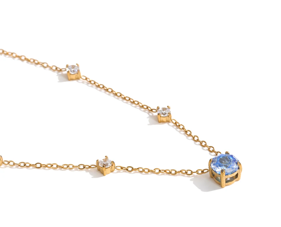 Shop the Bella Necklace: dainty gold station necklace with a blue zircon pendant. Waterproof, hypoallergenic stainless steel, adjustable.