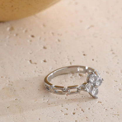 Silver ring with floral design on a beige surface