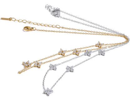 Two necklaces, one gold and one silver, with star-shaped pendants on a white background.