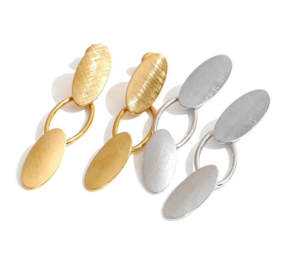 Three pairs of modern oval drop earrings on a clean white background. Two pairs are textured gold-tone metal, and one pair are brushed silver-tone metal.
