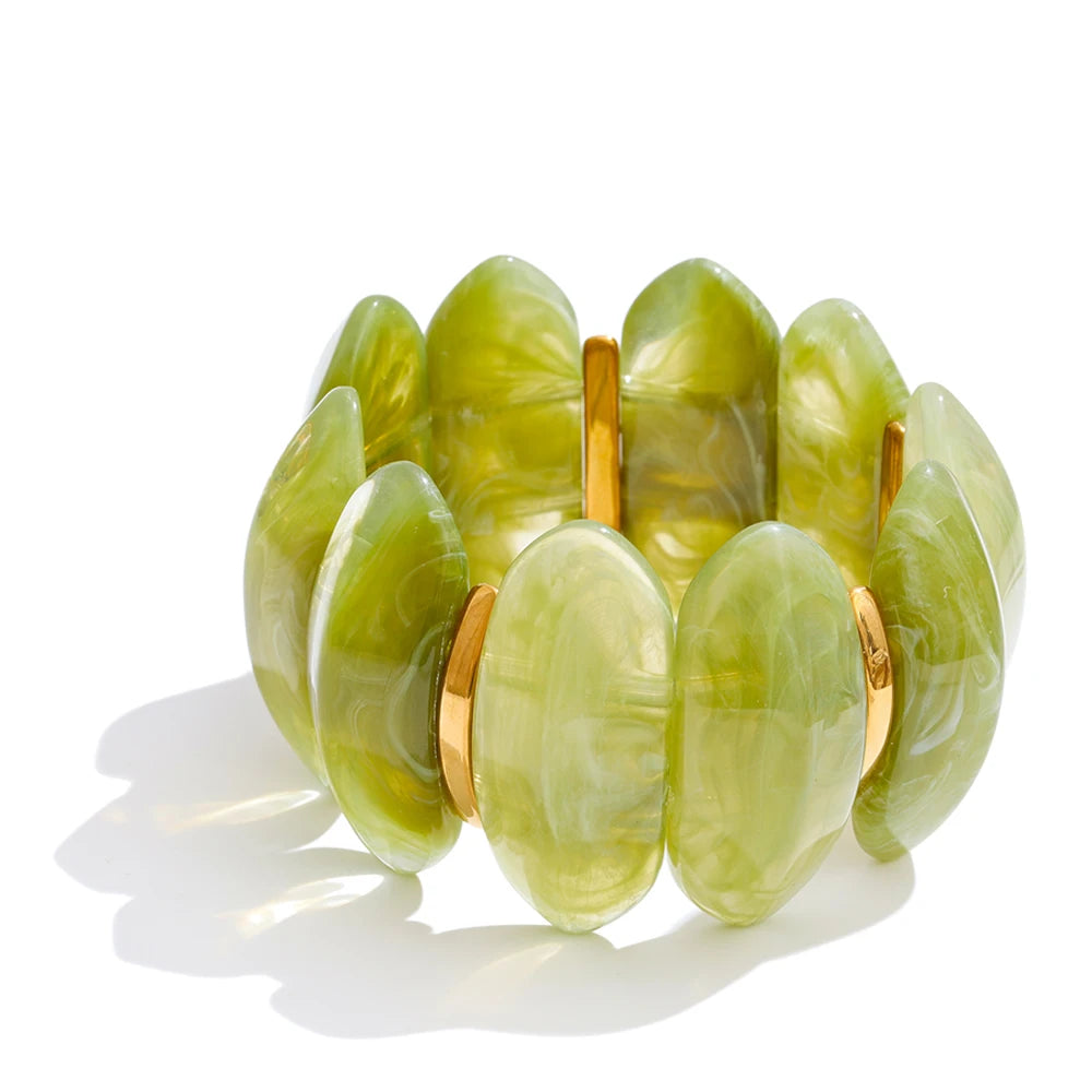 "Adalaide Bangle — chunky marbled resin beads in a sculptural wave design, finished with polished gold spacer links. A bold pop of color for stacking or wearing solo. Available in six rich marbled tones."