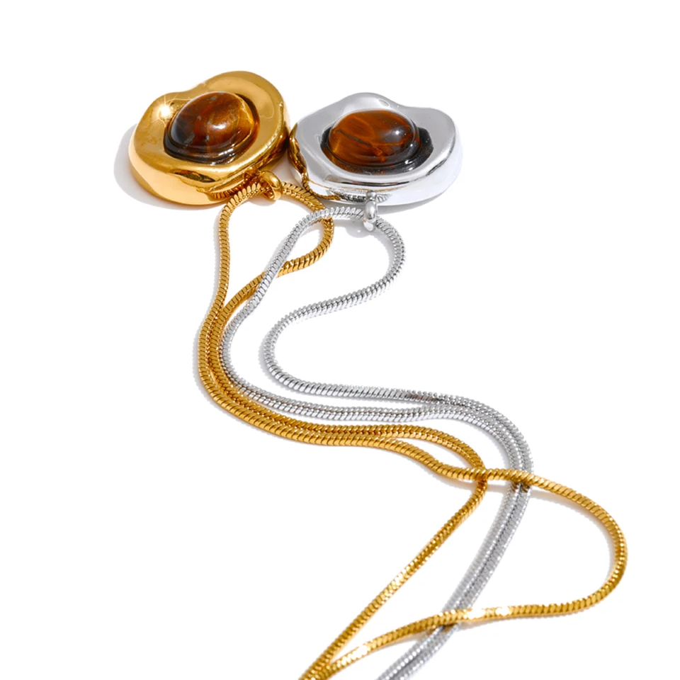 Gold and silver waterproof pendant with amber stones on a white background