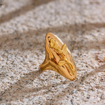 Gold ring with a unique design on a textured surface