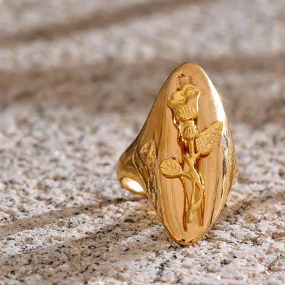 Gold ring with a detailed design on a textured surface